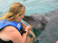 En kvinna fr en puss av en delfin.