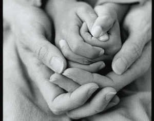 Ett barns händer omslutna av en vuxens.