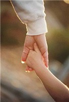 En vuxen hand som håller i ett barns hand.